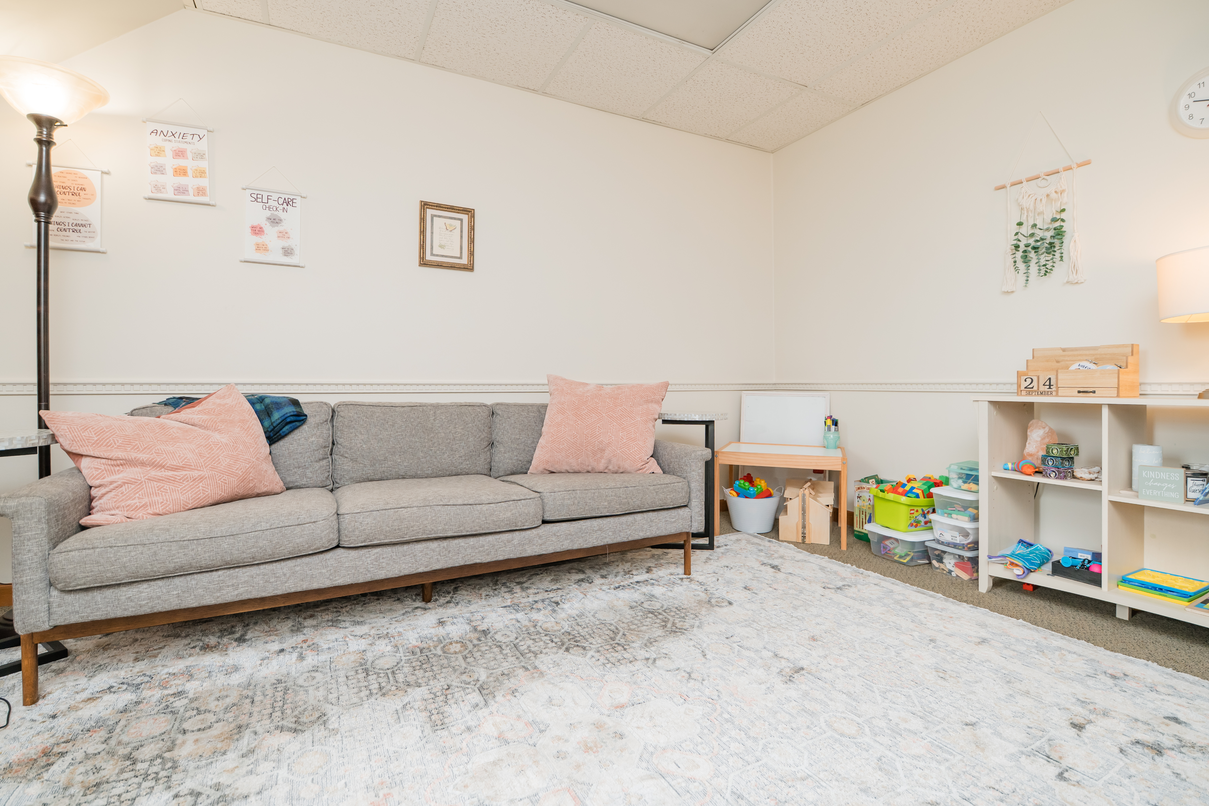 Bright room with gray couch and pink throw pillows.